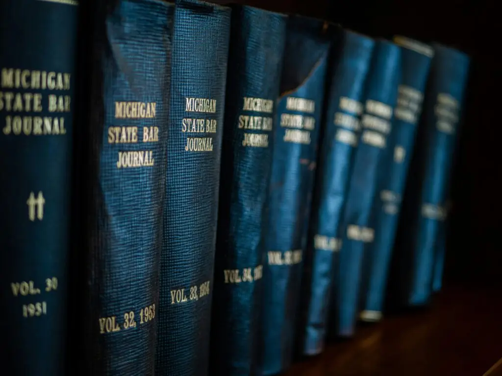 Fila di libri di legge rilegati in blu con incisioni dorate sullo scaffale⁠